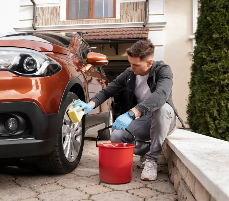 Lavage auto à domicile Pouilly-sur-Meuse : professionnel intervenant sur un véhicule